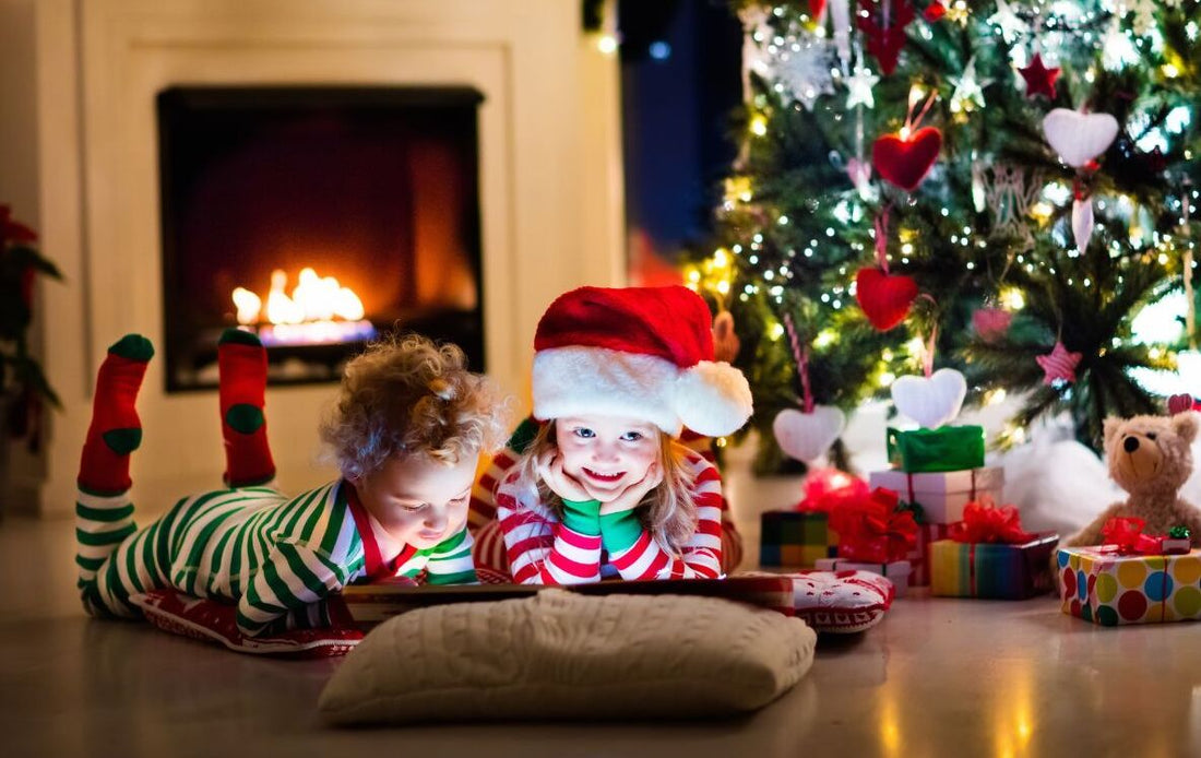 сhildren reading montessori book by Christmas tree